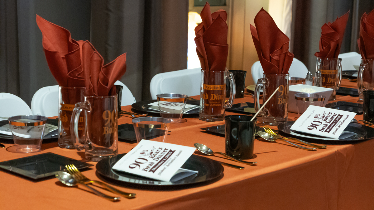 Image shows a table set with orange and black decorations.
